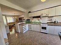 Rodinný dům s velkým potenciálem a navazujícím stavebním pozemkem v srdci Kamenného Újezdu! - Kuchyň spodního bytu a navazující obývací část