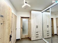 Byt  3+kk s dvěma balkóny, jedním parkovacím stáním v garáži a sklepem v Praze 9, Vysočany - chodba s vestavěným nábytkem