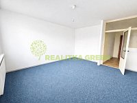 Prodej bytu 2+1 Zlín, ul. Luční, s balkonem, CP 60 m2 - Prázdný obývací pokoj s modrým kobercem.jpg