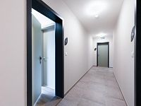 Pronájem novostavby 2 + kk s balkonem, parkovacím stáním a sklepem - pohled chodba-otevřené dveře.jpeg