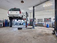 Veltěže – funkční autoservis 225 m2 , celý  objekt 1326 m2 , v Obci  Veltěže, okres Louny - Automobilová dílna s pozvednutým vozem.jpg